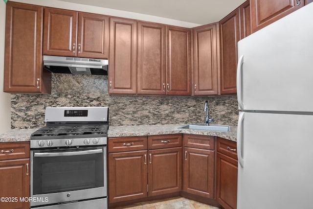 821 Woodland Dr, Lakewood, NJ 08701 - kitchen with freestanding refrigerator, gas range, under cabinet range hood, a sink, and backsplash