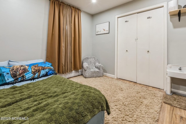 bedroom featuring a closet, baseboards, and wood finished floors