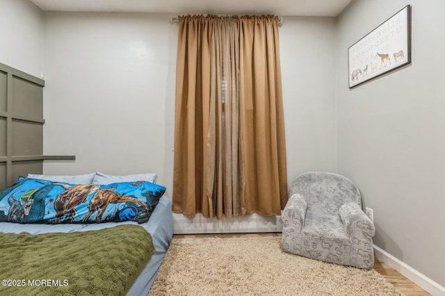 bedroom featuring wood finished floors and baseboards