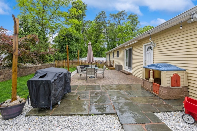 view of patio / terrace featuring fence, outdoor dining area, and a grill