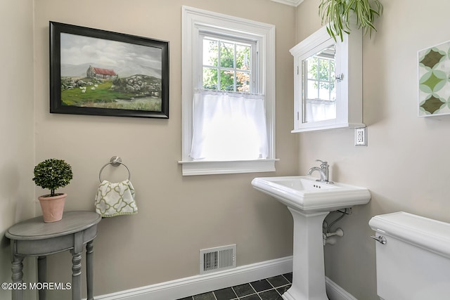 bathroom featuring toilet, tile patterned floors, and baseboards