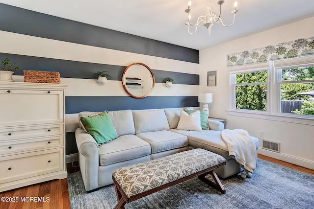 living area with a chandelier, dark wood-style flooring, and baseboards