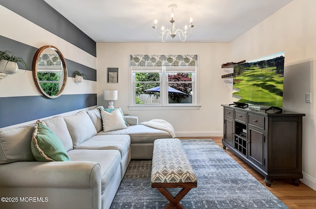 living area featuring a chandelier, wood finished floors, and baseboards