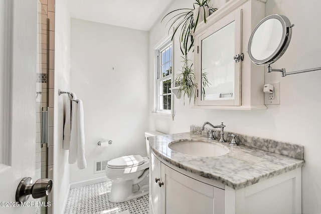 bathroom with toilet, vanity, baseboards, and a shower