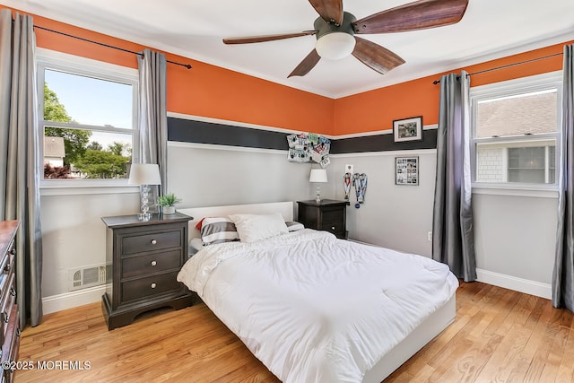 bedroom with light wood-type flooring, baseboards, and ceiling fan