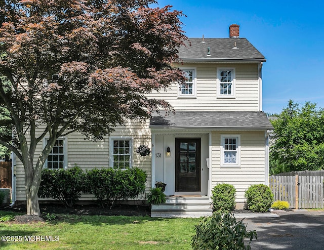 view of front of house with a chimney and a shingled roof