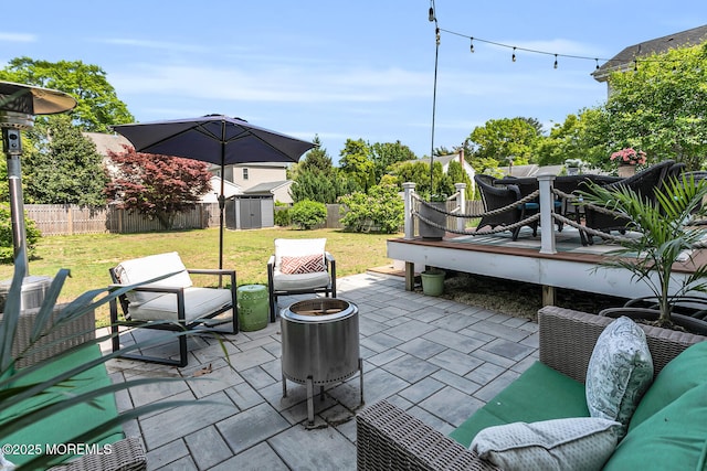 view of patio featuring a storage shed, an outbuilding, a deck, and outdoor lounge area