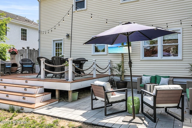 rear view of house featuring a wooden deck, fence, a patio, and an outdoor hangout area