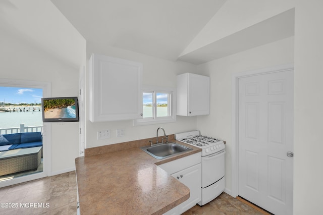 433 Bayside Ter Unit 1, Seaside Heights, NJ 08751 - kitchen with white gas stove, a sink, vaulted ceiling, and white cabinets