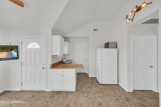 433 Bayside Ter Unit 1, Seaside Heights, NJ 08751 - kitchen featuring freestanding refrigerator, a sink, white cabinetry, vaulted ceiling, and baseboards