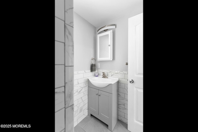 bathroom featuring tile walls, a wainscoted wall, vanity, and tile patterned floors