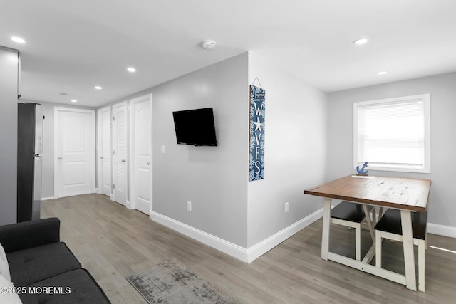 unfurnished living room with wood finished floors, recessed lighting, and baseboards