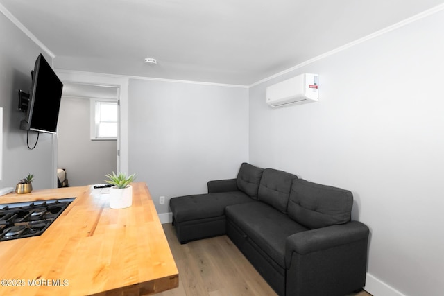 living area featuring a wall mounted air conditioner, wood finished floors, crown molding, and baseboards