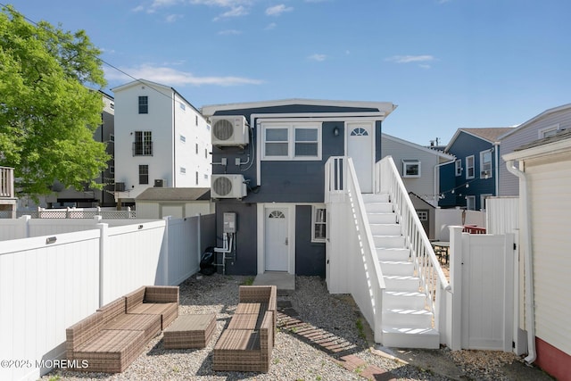 back of property featuring stairway, fence, ac unit, and outdoor lounge area