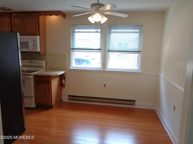 10A Molly Pitcher Blvd, Whiting, NJ 08759 - kitchen with white appliances, baseboard heating, brown cabinets, ceiling fan, and light wood-style flooring