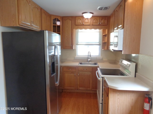 10A Molly Pitcher Blvd, Whiting, NJ 08759 - kitchen featuring white appliances, a sink, light wood-style floors, light countertops, and brown cabinetry