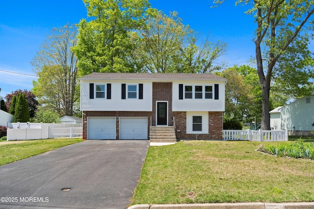 bi-level home with brick siding, driveway, a garage, and entry steps