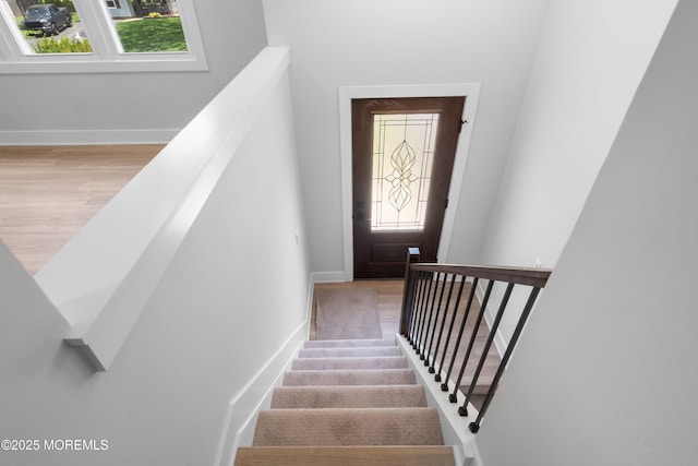 staircase featuring plenty of natural light and baseboards