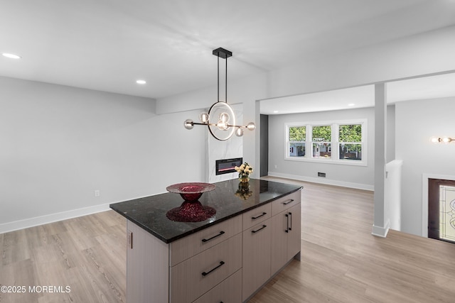 kitchen with open floor plan, light wood-style flooring, recessed lighting, a center island, and a chandelier
