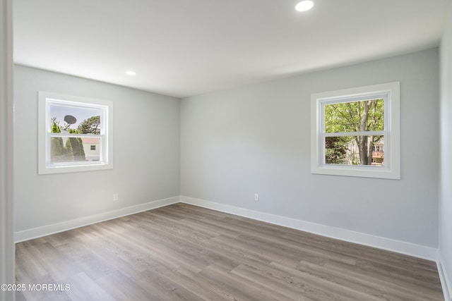 unfurnished room with baseboards, recessed lighting, and wood finished floors