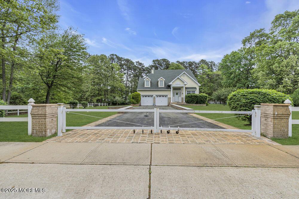 303 Diamond Rd, Jackson, NJ 08527 - view of front of home with an attached garage, view of wooded area, and asphalt driveway