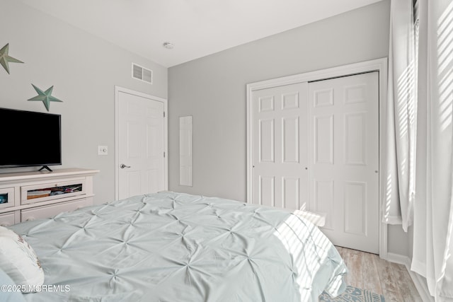 bedroom featuring light wood finished floors and a closet