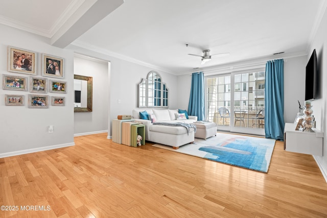 living room featuring ornamental molding, light wood finished floors, ceiling fan, and baseboards