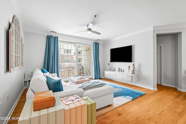 living room with a ceiling fan, wood finished floors, crown molding, and baseboards