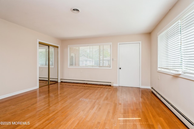 821 Jamaica Blvd, Toms River, NJ 08757 - unfurnished bedroom featuring a baseboard heating unit, a baseboard radiator, light wood-type flooring, and baseboards