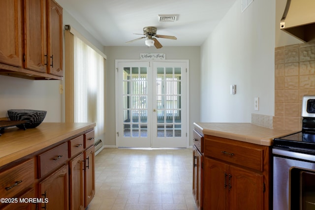 113 Ash Rd Unit 8, Manahawkin, NJ 08050 - kitchen with stainless steel electric range oven, ceiling fan, extractor fan, brown cabinets, and baseboard heating