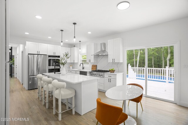 781 Harmony Rd, Jackson, NJ 08527 - kitchen featuring appliances with stainless steel finishes, wall chimney exhaust hood, a kitchen bar, white cabinetry, and recessed lighting