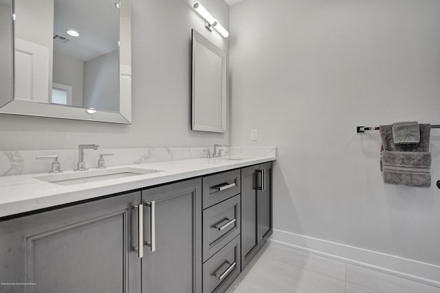 full bath with baseboards, double vanity, and tile patterned flooring