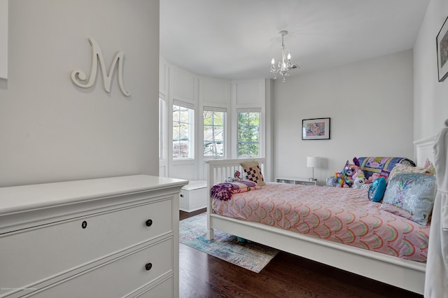 bedroom with a chandelier and dark wood finished floors