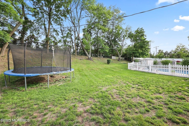 view of yard with a trampoline and a swimming pool