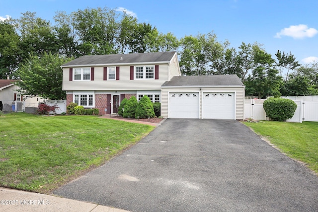 colonial home featuring a gate, a garage, asphalt driveway, and brick siding