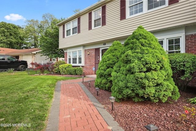 view of front of house featuring brick siding and a front yard