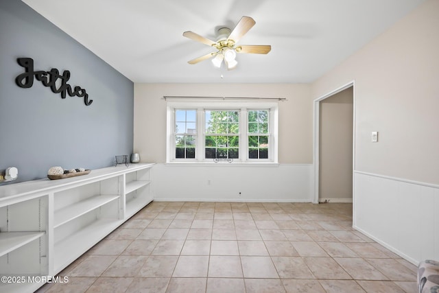 empty room with a ceiling fan and light tile patterned floors