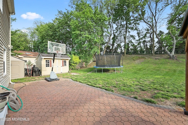 view of patio featuring a trampoline, a storage shed, and an outbuilding