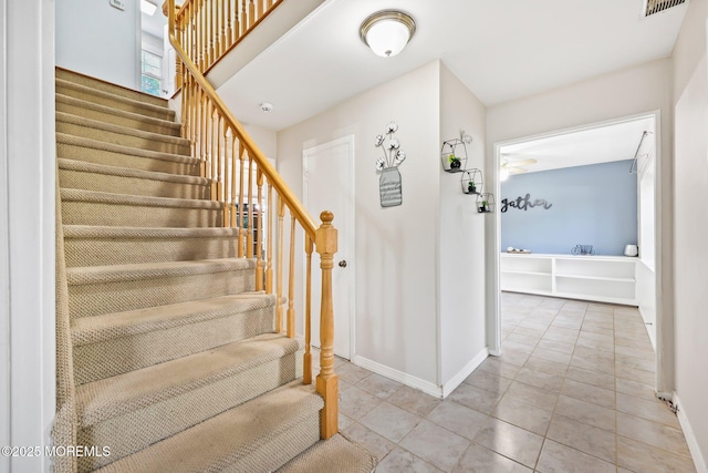 stairs with baseboards and tile patterned floors