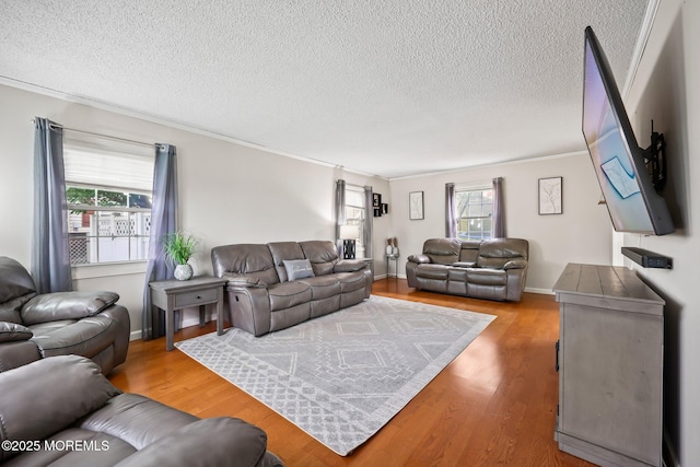 living room with a textured ceiling, crown molding, and wood finished floors