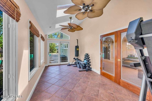 sunroom featuring french doors, baseboards, a skylight, and high vaulted ceiling