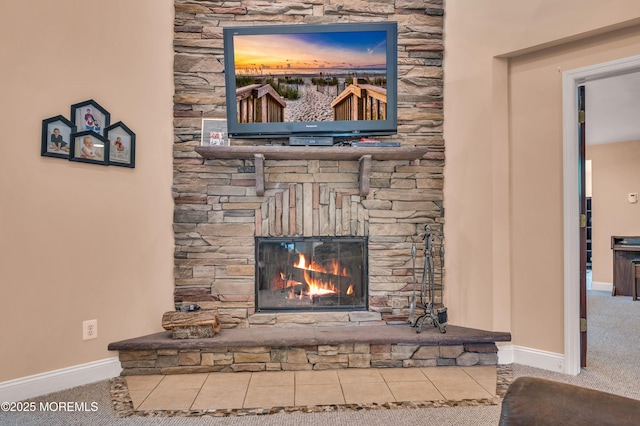 detailed view of a fireplace, baseboards, and carpet flooring