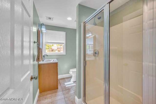 bathroom featuring a shower stall, toilet, vanity, tile patterned flooring, and baseboards