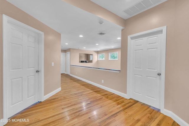 empty room with light wood-type flooring, baseboards, and recessed lighting