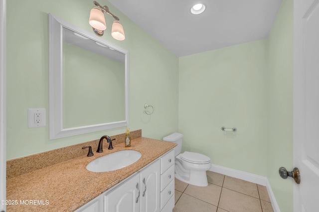 bathroom with tile patterned floors, toilet, vanity, and baseboards