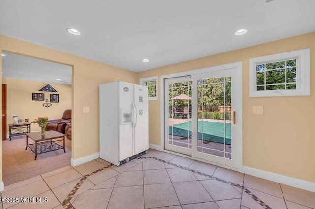 doorway with light tile patterned floors, baseboards, and recessed lighting