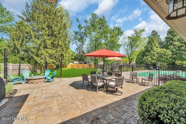 view of patio featuring a fire pit, outdoor dining area, and view of scattered trees