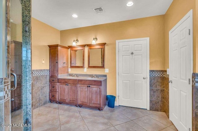 bathroom featuring tile walls, a wainscoted wall, vanity, tile patterned floors, and recessed lighting