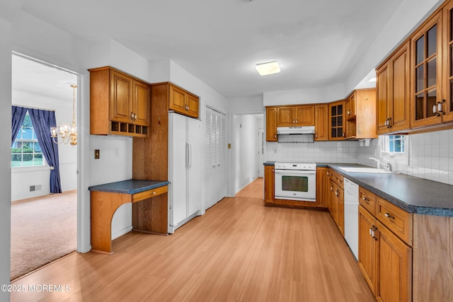 132 Tunes Brook Dr, Brick, NJ 08723 - kitchen with white appliances, a sink, under cabinet range hood, brown cabinets, and a chandelier