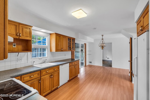 132 Tunes Brook Dr, Brick, NJ 08723 - kitchen with white dishwasher, a sink, brown cabinetry, tasteful backsplash, and light wood finished floors